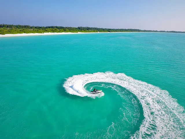 Moto de agua trazando una curva sobre una laguna turquesa
