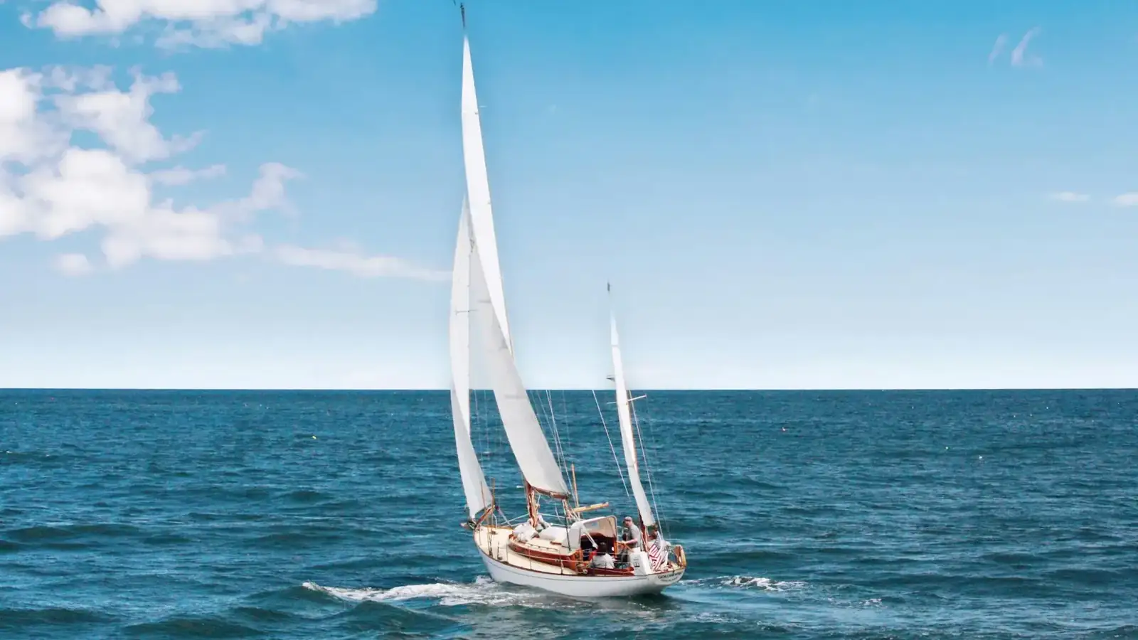 Velero de crucero navegando con todas las velas en mar abierto
